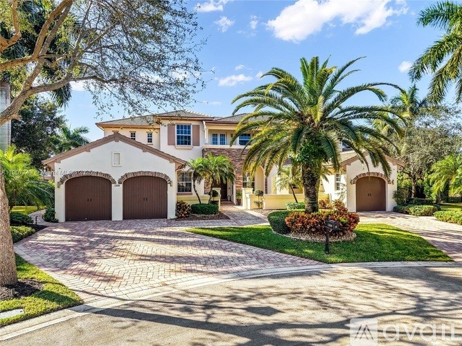 A house with a driveway and palm trees in front.