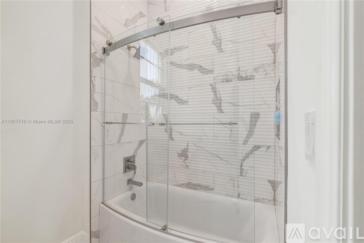 A glass shower door with a white background.