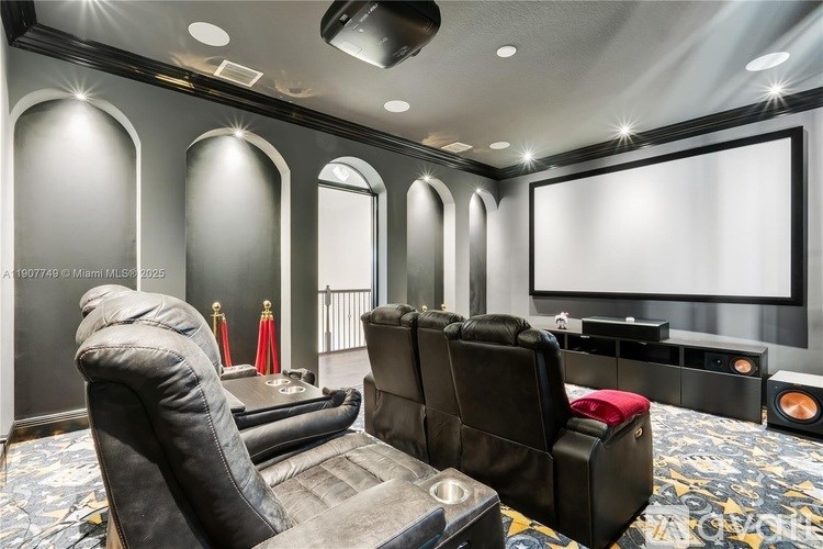 A home theater with black leather chairs and a large screen.