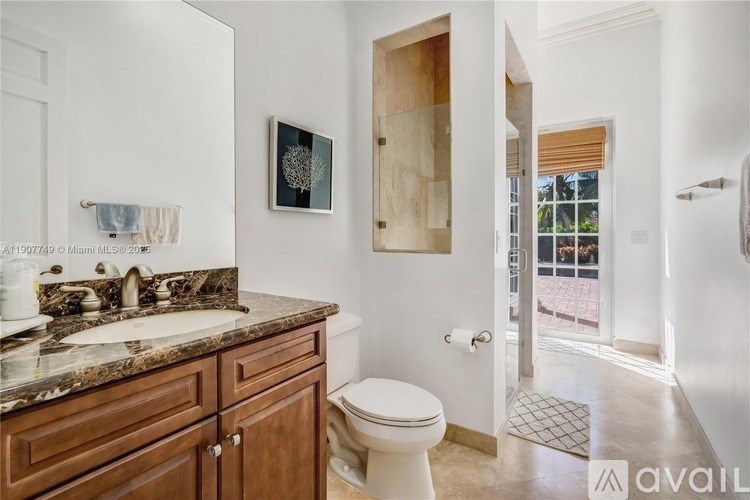 A bathroom with a marble countertop and a toilet.