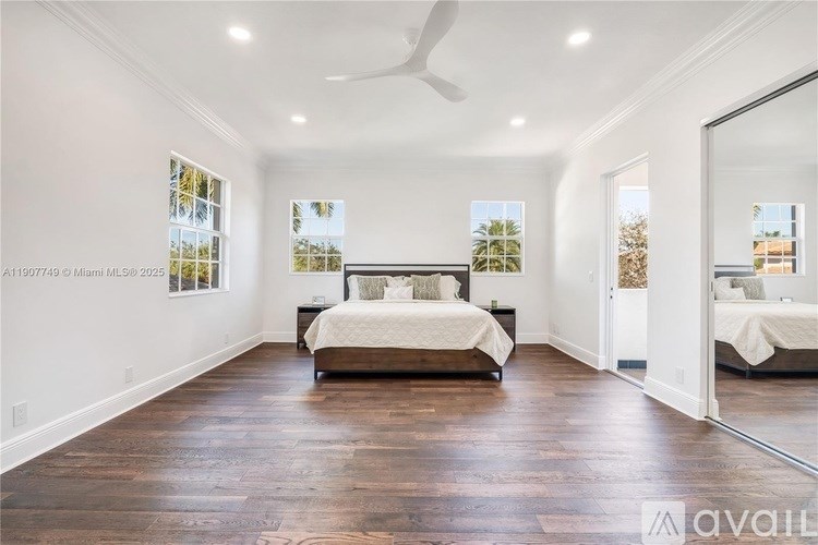 A bedroom with a large bed and a ceiling fan.