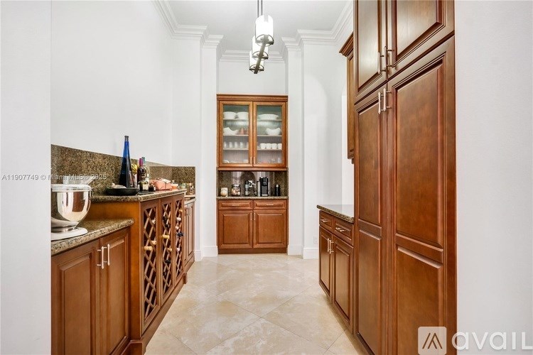A kitchen with wooden cabinets and a marble countertop.