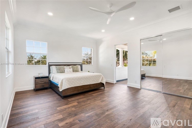 A bedroom with a large bed and wooden floors.