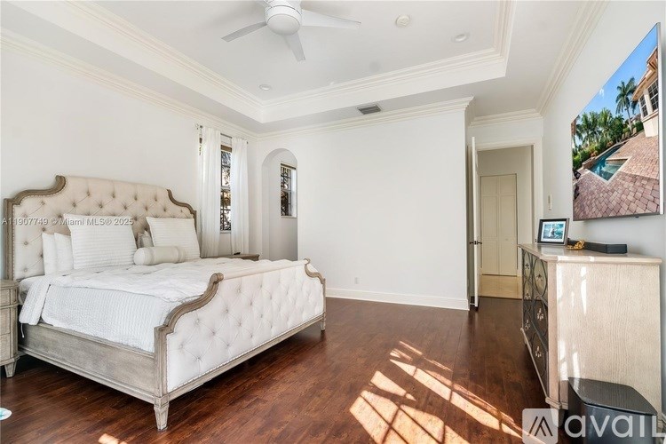 A bedroom with a large bed and a wooden floor.