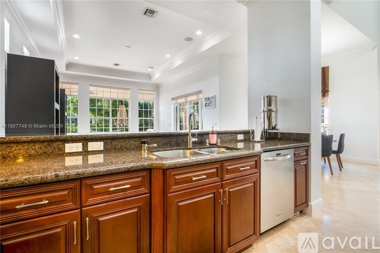 A kitchen with brown cabinets and a granite countertop.