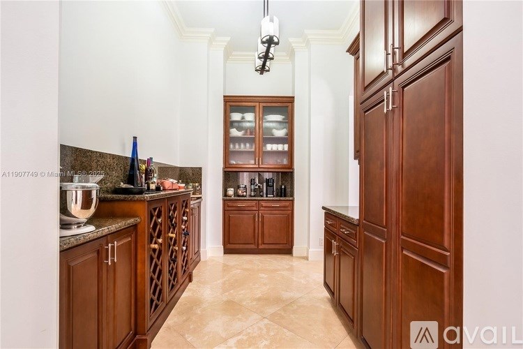 A kitchen with wooden cabinets and a marble countertop.