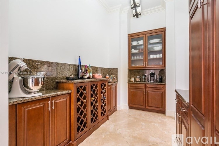A kitchen with wooden cabinets and a marble countertop.