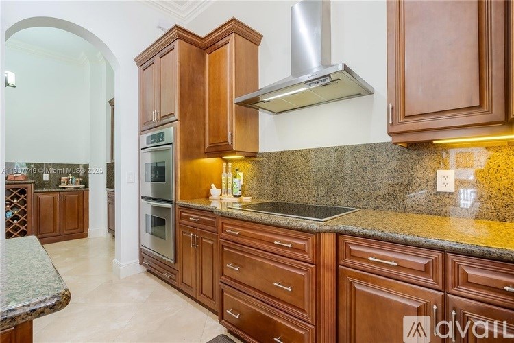 A kitchen with wooden cabinets and a granite countertop.