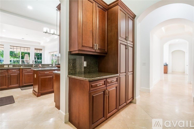 A kitchen with brown cabinets and a marble countertop.