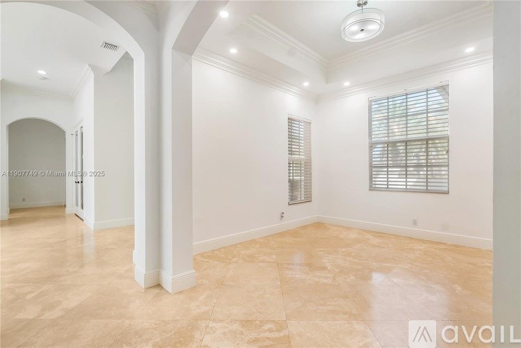 A spacious room with a tiled floor and a window with blinds.