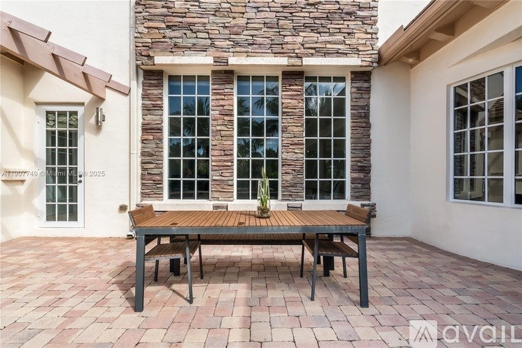 A patio with a table and chairs is set up outside a house.