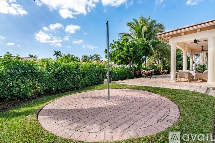 A circular brick patio with a pole in the middle.