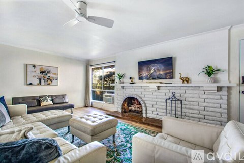 A living room with a fireplace and a painting on the wall.