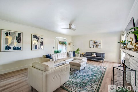 A living room with a white couch and a rug.
