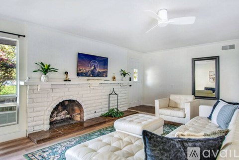 A living room with a fireplace and a painting on the wall.