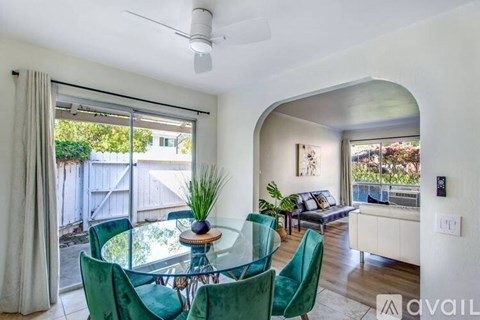 A modern living room with a glass table and green chairs.