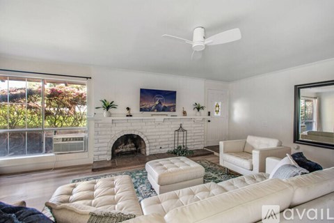 A living room with a white couch and a fireplace.