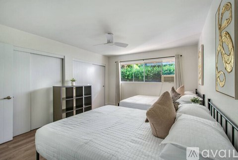 A bedroom with a large bed and a ceiling fan.