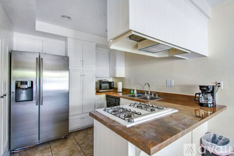 A kitchen with a stainless steel refrigerator and a wooden countertop.
