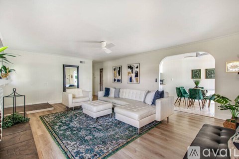 A living room with a white couch and a rug.