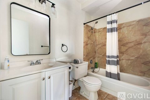 A bathroom with a toilet, sink, and bathtub.