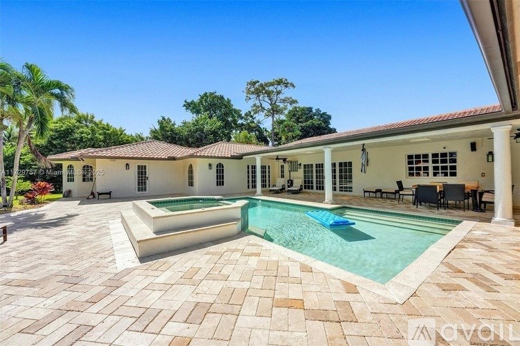 A large house with a pool in front.