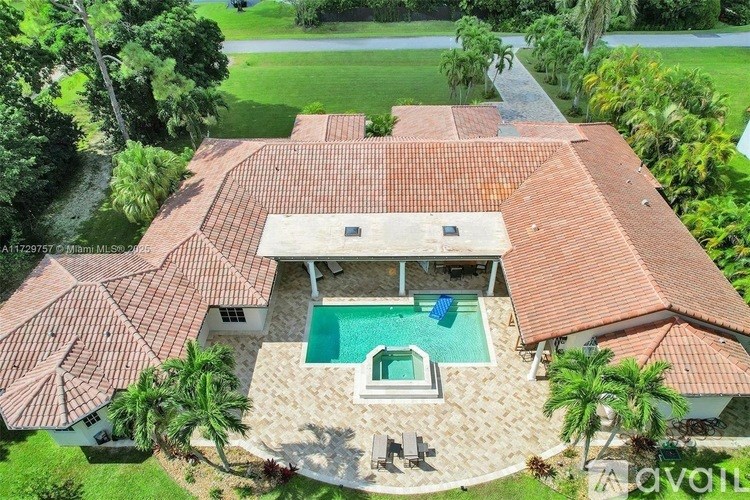 A large house with a red tiled roof and a pool in the backyard.