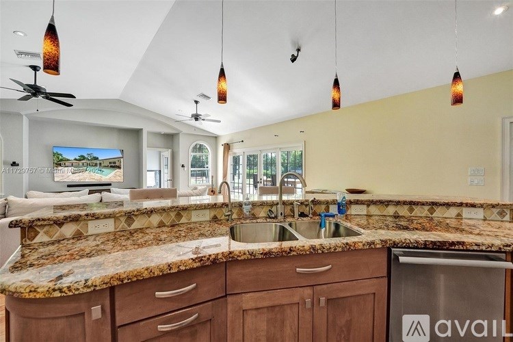 A kitchen with a granite countertop and wooden cabinets.
