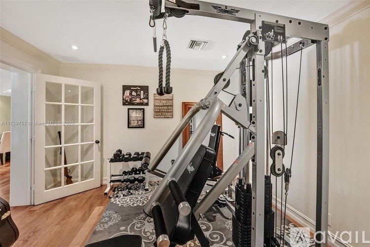 A home gym with a squat rack and dumbbells.
