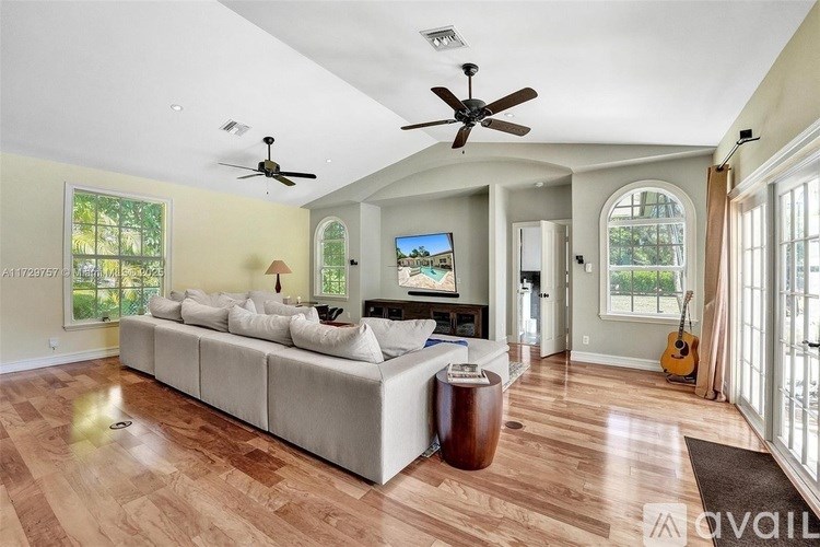 A living room with a white couch and a ceiling fan.