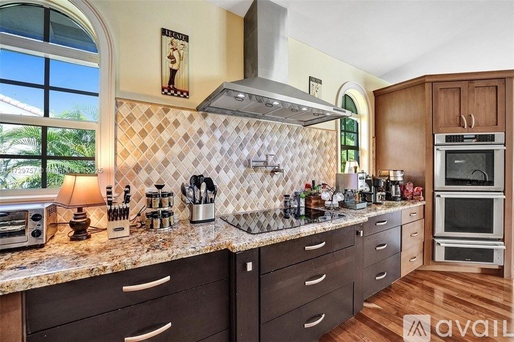 A kitchen with a tile backsplash and wooden cabinets.