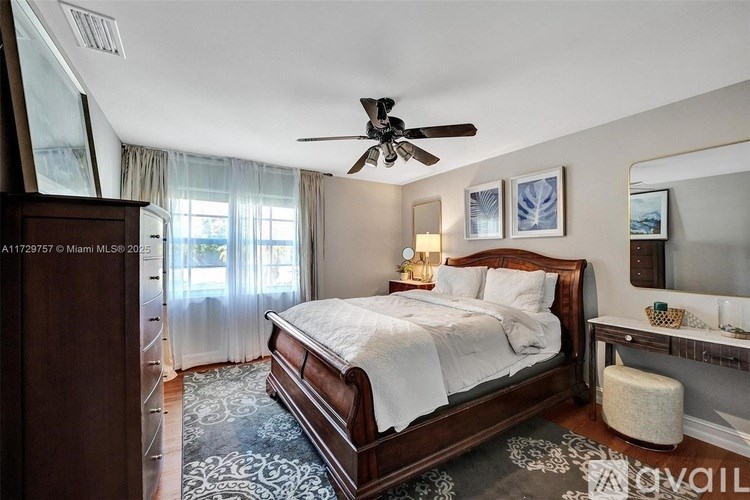 A bedroom with a large bed and a ceiling fan.