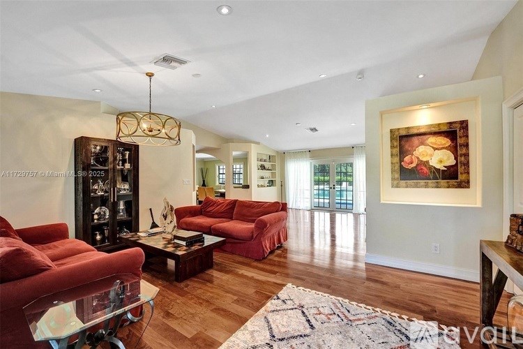 A living room with red couches and a glass coffee table.