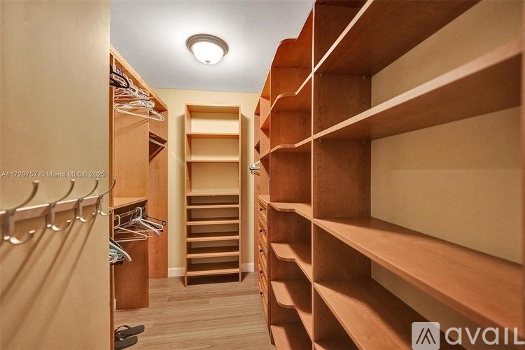 A spacious walk-in closet with wooden shelves and drawers.