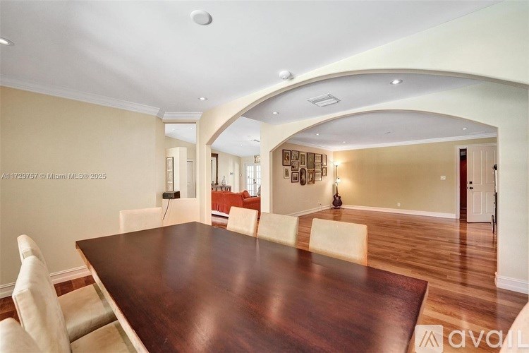 A dining room with a wooden table and chairs.