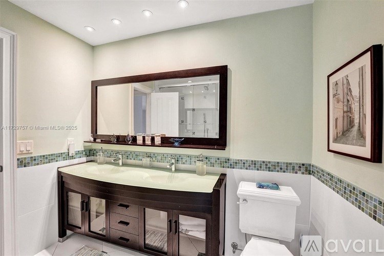 A bathroom with a sink, mirror, and toilet.