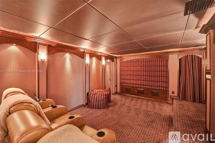 A room with a row of leather chairs facing a screen.