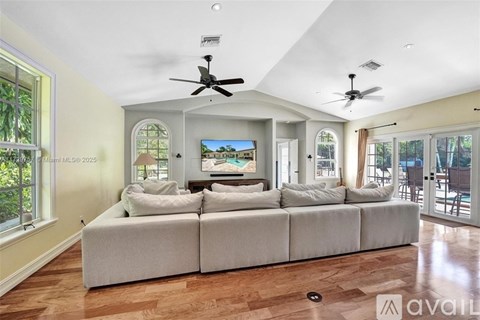 A spacious living room with a large sectional sofa and a television.