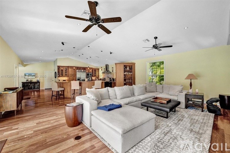 A living room with a white couch and a ceiling fan.