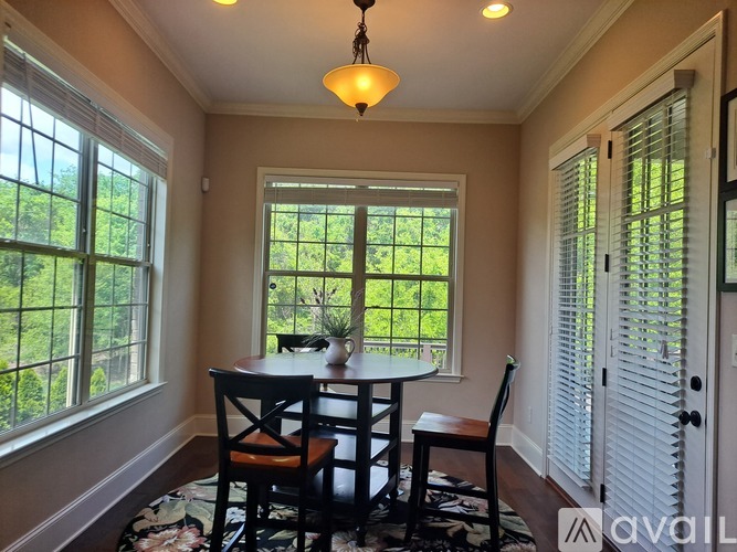 A dining room with a table and chairs.