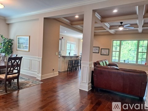A living room with a brown couch and a ceiling fan.