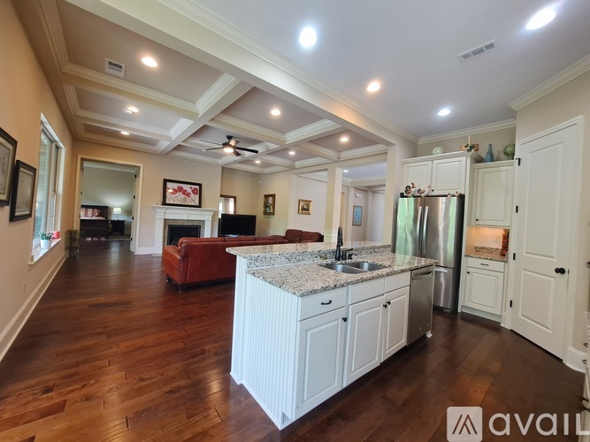 A spacious kitchen with white cabinets and a central island.