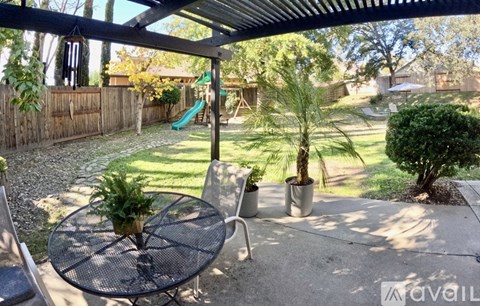 A patio with a table and chairs under a roof.