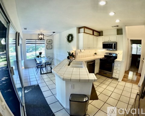 A kitchen with white cabinets and a large island.