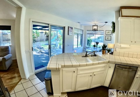 A kitchen with white cabinets and a sink.