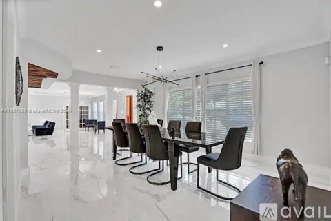 A modern dining room with a glass table and chairs.