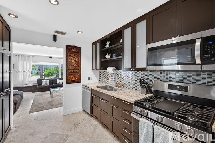A modern kitchen with a stainless steel refrigerator and a microwave above the stove.