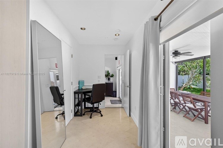A room with a desk and chairs is shown in a real estate listing.