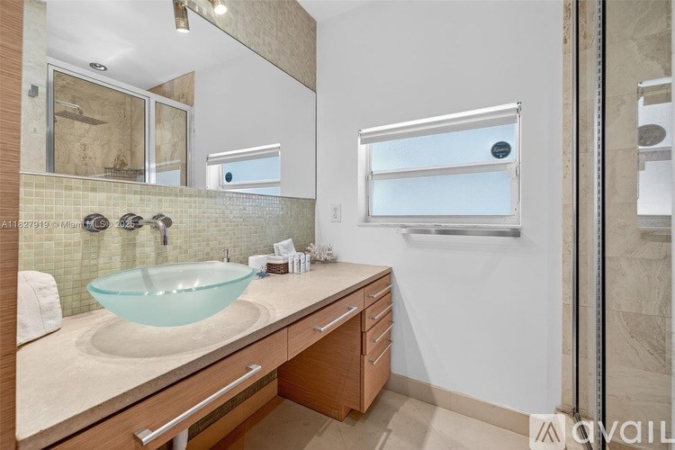 A bathroom with a glass sink and a window.