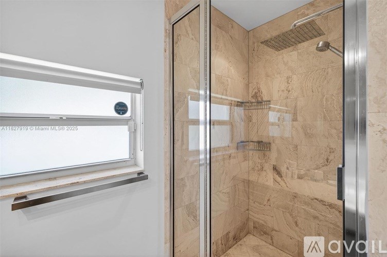 A shower area with a glass door and a tiled wall.